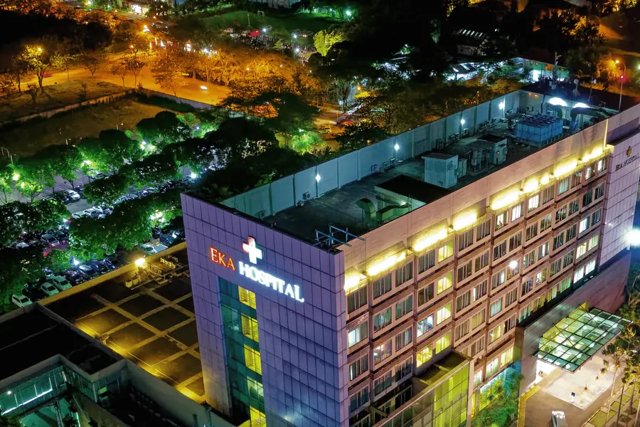Hospital à noite visto de cima, com pátio de estacionamento
